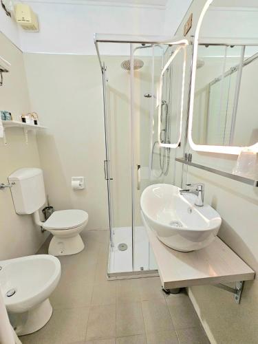 a bathroom with a toilet and a sink and a shower at Hotel Tahiti in Viareggio