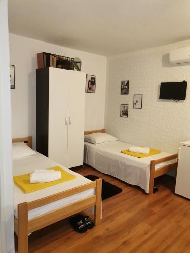a room with two beds and a white cabinet at Studio Sofia in Novalja