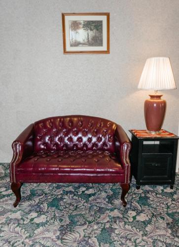 a brown leather couch sitting next to a lamp on a table at Carriage House Country Club in Pocono Manor
