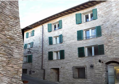 een bakstenen gebouw met groene luiken erop bij Camere Gambacorta Assisi in Assisi