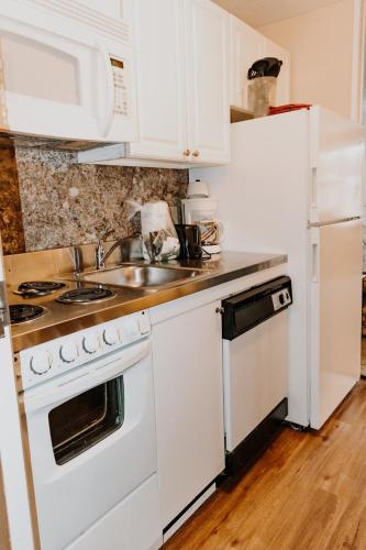 a white kitchen with a sink and a refrigerator at Carriage House Country Club in Pocono Manor