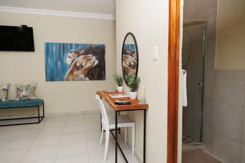 a bathroom with a small table and a mirror at Lions View Accommodation in Nelspruit