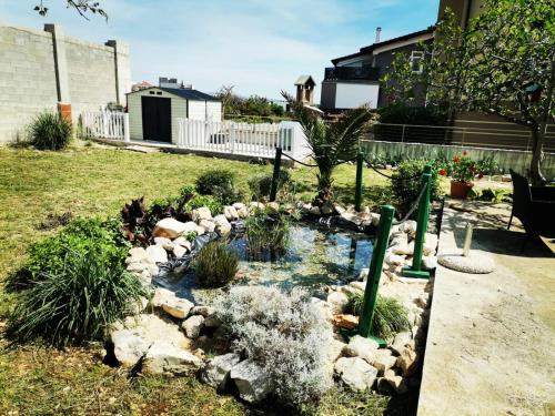 a garden with a pond in the yard at Studio Sofia in Novalja
