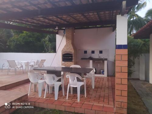 a patio with a table and chairs and a fireplace at Ilha , Vera Cruz, Cacha Pregos um lugar lindo e tranquilo ! in Vera Cruz de Itaparica