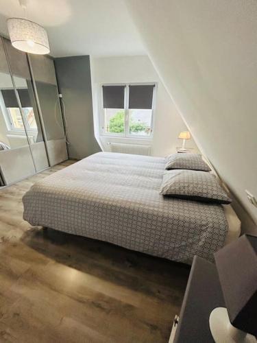 une chambre avec un lit et deux fenêtres dans l'établissement Le Gîte de La Baie A Velo, à Nouvion-en-Ponthieu