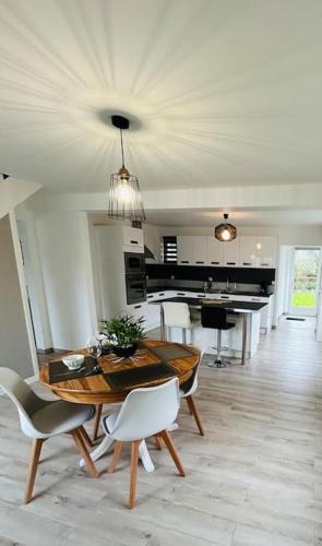 une salle à manger avec une table et des chaises et une cuisine dans l'établissement Le Gîte de La Baie A Velo, à Nouvion-en-Ponthieu