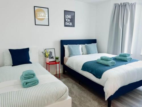 ein Schlafzimmer mit 2 Betten und Handtüchern darauf in der Unterkunft Spacious 1-Bed Flat Near Wembley Stadium in London