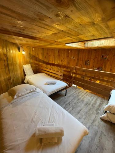 una habitación con dos camas en una cabaña de madera en La Cabane Tonneau - Les Pieds dans le Pré, en Les Landes-Génusson