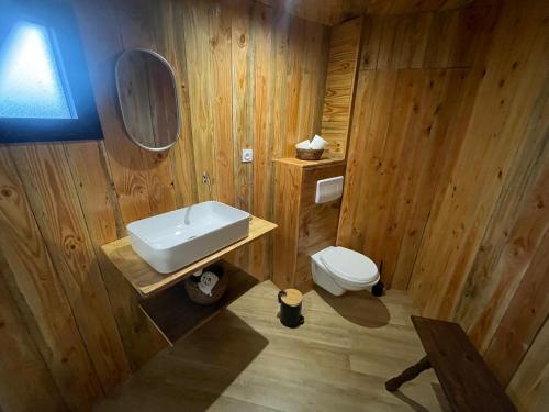 Un baño de madera con lavabo e inodoro. en La Cabane Tonneau - Les Pieds dans le Pré, en Les Landes-Génusson