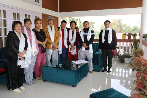 un gruppo di persone che posano per una foto in una stanza di Tsering's Homestay Oyan a Pāsighāt