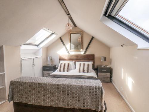 um quarto com uma cama grande num sótão em Stakesby Villa Whitby em Whitby