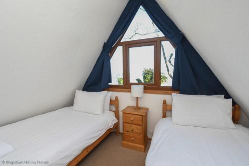 two twin beds in a room with a window at Chalet Seventeen in Deal