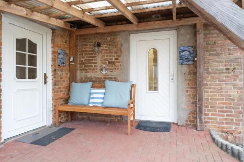 a wooden bench sitting on a brick patio at Strand Familien Doppelhaushälfte ,,MARSI'' #Familien-Urlaub in Rappin