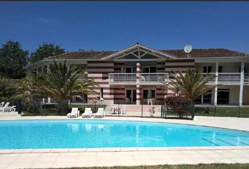 a house with a swimming pool in front of a house at Villa de 6 pers, 500m plage. in Soulac-sur-Mer