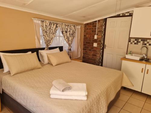 ein Schlafzimmer mit einem Bett mit Handtüchern darauf in der Unterkunft Home Sweet Home in Polokwane