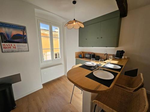 une cuisine avec une table, des chaises et des verres. dans l'établissement Suite au Cœur de la Citadelle by Monarca, à Bastia