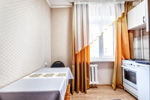 Habitación pequeña con cama y ventana en Золотой квадрат, en Astana