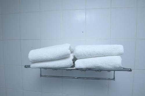 a stack of towels on a shelf in a bathroom at Beautiful 4-Bed House in Erith in Erith