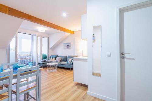 a kitchen and living room with white walls and wood floors at App 7o KleinerTag am Meer in Dranske