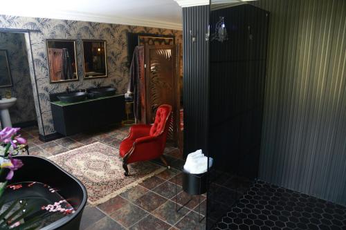 a bathroom with a red chair and a sink at Villa Grande Luxury accommodation in Welkom