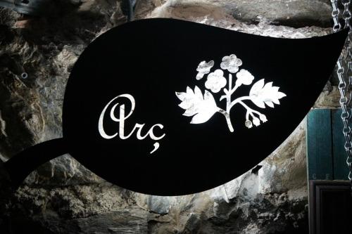 a black sign with white flowers on it at Masia Can Constans in Queralbs