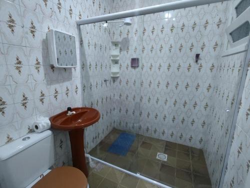 a bathroom with a toilet and a sink at Pousada Golfinhos in Imbé