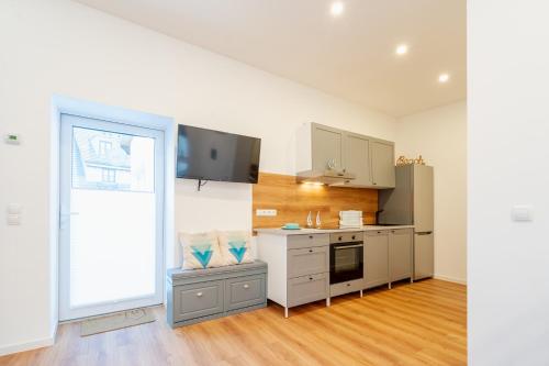 a kitchen with white cabinets and a large window at App 8u Heimatliebe in Dranske