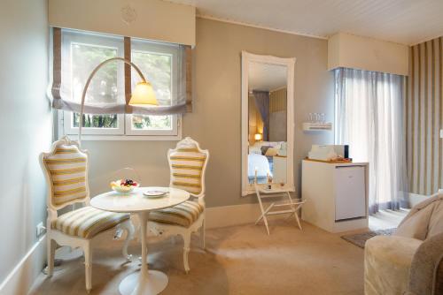 a living room with a table and chairs at Casa Regaleira Hotel Boutique in Campos do Jordão