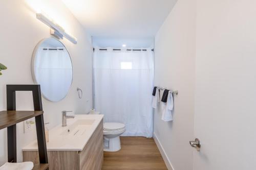 a bathroom with a sink and a toilet and a mirror at King-Size Bed, Parking Free Near Brickell & Grove in Miami