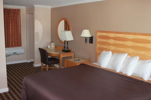 Cette chambre comprend un lit et un bureau. dans l'établissement Cape Cod Inn, à Hyannis