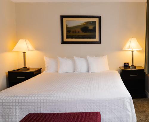 a bedroom with a large white bed with two lamps at Carriage House Country Club in Pocono Manor