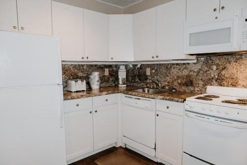 a white kitchen with white cabinets and a sink at Carriage House Country Club in Pocono Manor