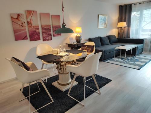 a living room with a table and chairs and a couch at FeWo Segelwind in Bodman-Ludwigshafen