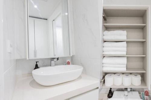 W łazience znajduje się umywalka, lustro i ręczniki. w obiekcie Mirae Stay 71 w Seulu