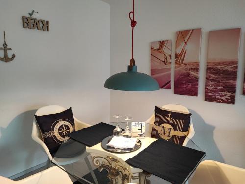 a dining room with a table and chairs and aendant light at FeWo Segelwind in Bodman-Ludwigshafen