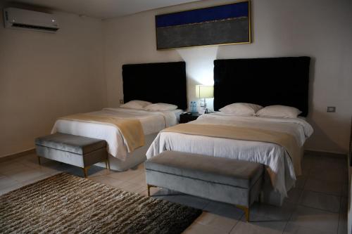 Cuatrociénegas de Carranza的住宿－HOTEL SERENNA，酒店客房,配有两张床和椅子