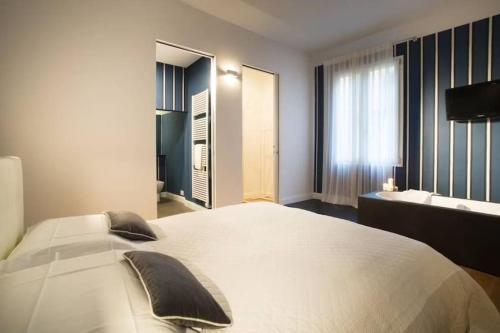 a bedroom with a large white bed and a bathroom at Tornabuoni TOT - luxury apartments in Florence