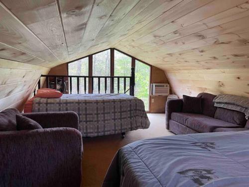 a room with two beds and a couch in a house at Hocking Hills Cottage with beautiful pond in Logan