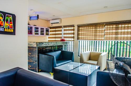 a restaurant with couches and a table and chairs at E45 Hotels and Suites in Owerri