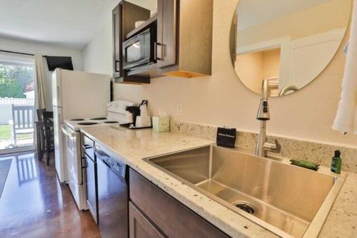 a kitchen with a sink and a refrigerator at Nader's Motel & Suites in Ludington