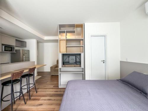 a bedroom with a bed and a table and chairs at Studio Premium Florianópolis in Florianópolis
