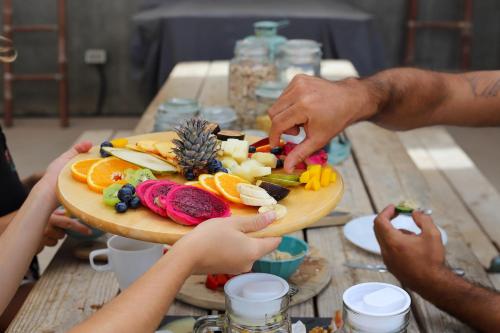 a group of people holding a plate of food on a table at Villa Koa - Riders Surf n Bike in El Roque