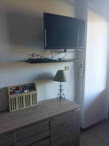 a flat screen tv sitting on top of a dresser at Appartement avec piscine partagée in Calenzana