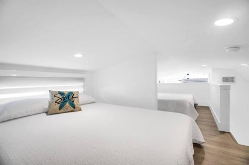 a white bedroom with two beds and a pillow at Tiny Home on Waterfront, Bay Views, Deck, Pool in Jewfish