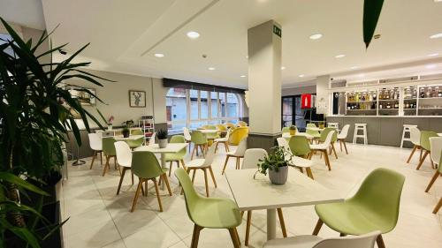 a restaurant with tables and chairs and a cafeteria at Hotel Bradomin in Villanueva de Arosa