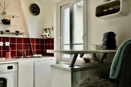 a kitchen with a counter with a table in it at Pegase in Deauville
