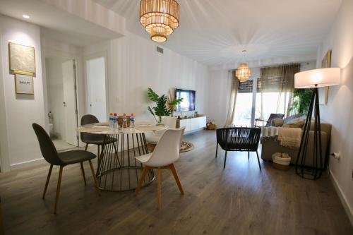 a living room with a dining room table and chairs at Aguacate Beach Apartamentos Playa Granada in Motril