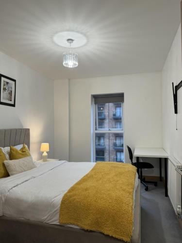a bedroom with a bed and a desk and a window at Luxury Apartment in Dartford in Dartford