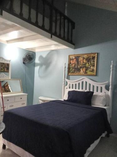 a bedroom with a large bed with a blue blanket at Apartment by the Beach Sleeps 4 in Ocho Rios