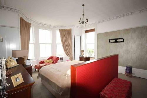 1 dormitorio con 1 cama, 1 silla y ventanas en Island Seaview Villa with Swim Spa & Sauna, en Rothesay